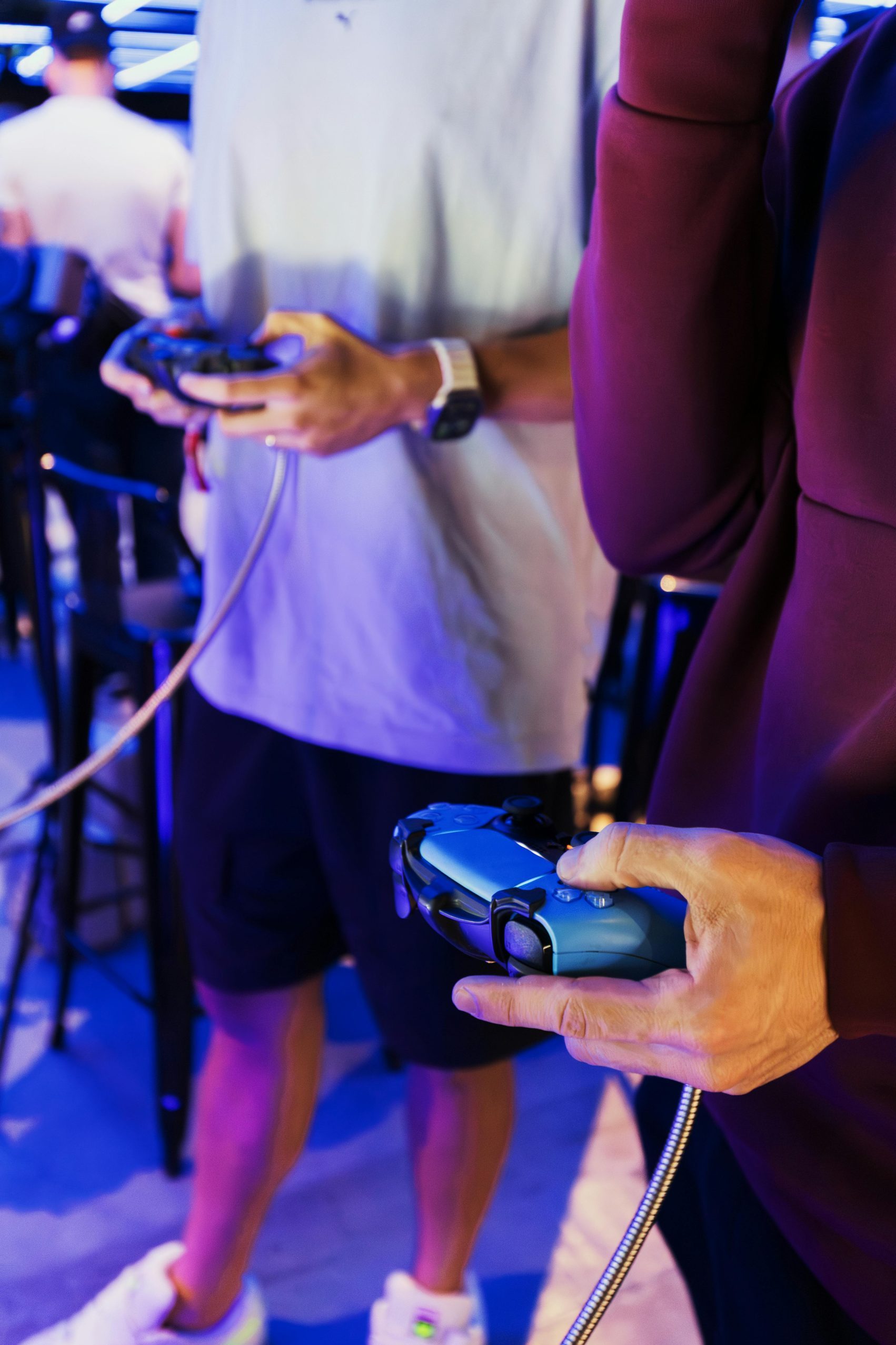 Two teenagers engrossed in a gaming session, holding controllers in a vibrant gaming environment.